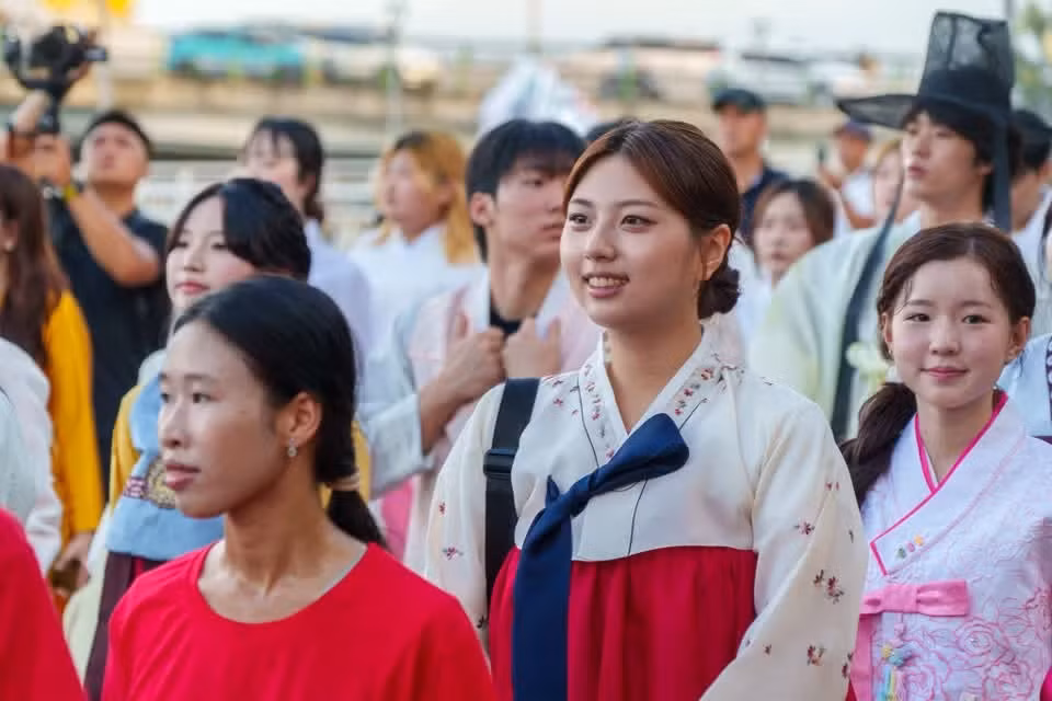 一名身着传统服饰的韩国青年融入游行队伍。图自Vietnam+