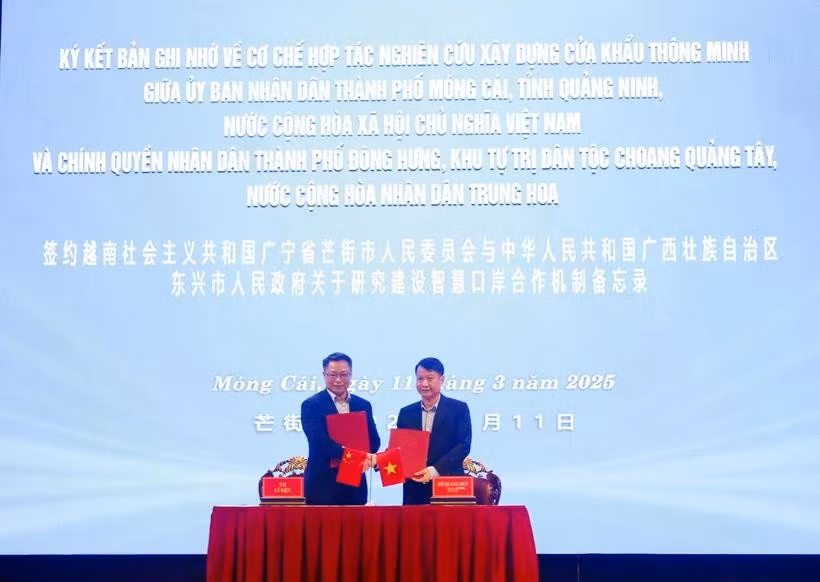 芒街市人民委员会主席胡光辉与东兴市人民政府市长李健共同签署了《芒街市与东兴市关于研究建设智慧口岸合作机制的谅解备忘录》。图自越通社