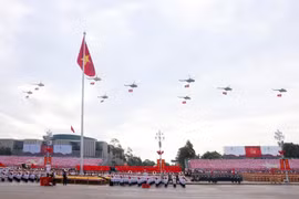 人民空军直升机编队悬挂党旗与国旗飞越河内上空。图自越通社