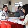 林同省活动能乡公务员在新下村的流动公共行政服务点指导民众办理司法、户籍手续。图自越通社