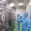IVAC研究院的研究人员在疫苗生产流程中操作设备。图自越通社