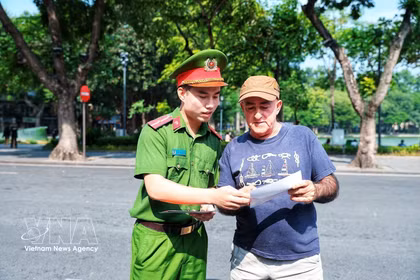 公安干部向一名外国游客介绍“智能警察站”功能。图自越通社