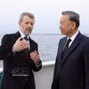 丹麦国王弗雷德里克十世在乘船前往利奈特霍尔姆岛途中，向越共中央总书记、国家主席苏林介绍利奈特霍尔姆人造岛项目。图自越通社