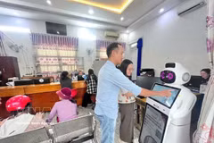 附图：人工智能机器人协助民众查询办事手续和获取排队号码。图片：越通社