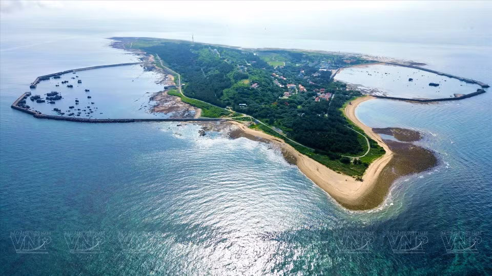 从高空俯瞰白龙尾岛全景，南北两座风暴避难所船闸正在紧急完工。图自越通社《越南画报》