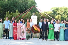 旅居哈瓦那越南人代表在胡志明主席塑像献花。图自越通社