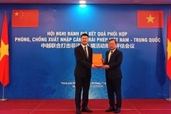 越南公安部出入境管理局局长范登科中将向中方代表赠送纪念品。图自cand.com.vn