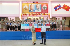 越南驻老挝大使馆代表团看望慰问阮攸老越双语学校师生。图自越通社