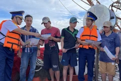 海上执法力量在渔船出海捕鱼前向渔民宣传有关非法、不报告和不受管制（IUU）捕捞的规定。