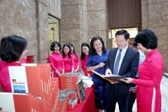 越南政府副总理梅文政参观越英双语画册《A80：祖国在心中》展览。图自越通社