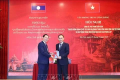 越共中央书记处书记、中央办公厅主任黎淮忠向老挝人民革命党中央书记处书记、中央办公厅主任通沙立·蒙诺梅赠送《越共中央办公厅和老挝人民革命党中央办公厅合作关系传统》一书。图自越通社
