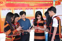 岘港市茶灵乡色当族同胞正在用手机查看有关第十六届国会及各级人民议会代表选举的视频和图表新闻，了解投票流程。图自越通社