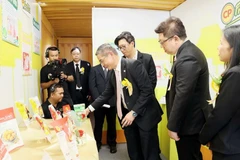 新加坡驻胡志明市总领事彭迪成参观C.P.（越南）股份公司展位展出的产品。图自《同奈报》