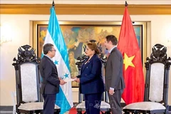 越南驻墨西哥兼驻洪都拉斯大使阮文海向洪都拉斯总统伊丽丝·希奥玛拉·卡斯特罗·萨缅托（Xiomara Castro）递交越南国家主席梁强的委任书。图自越通社