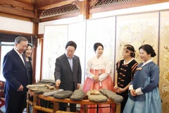 苏林总书记夫妇向韩国总统李在明夫妇介绍越南石琴艺术。图自越通社