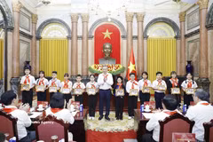 越共中央总书记、国家主席苏林向胡志明少年先锋队优秀队员赠送《胡伯伯与儿童》图片。图自越通社
