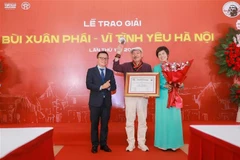 越南记者协会主席、《人民报》总编辑黎国明与越通社社长武越庄为陈进颁授“热爱河内”大奖。图自越通社