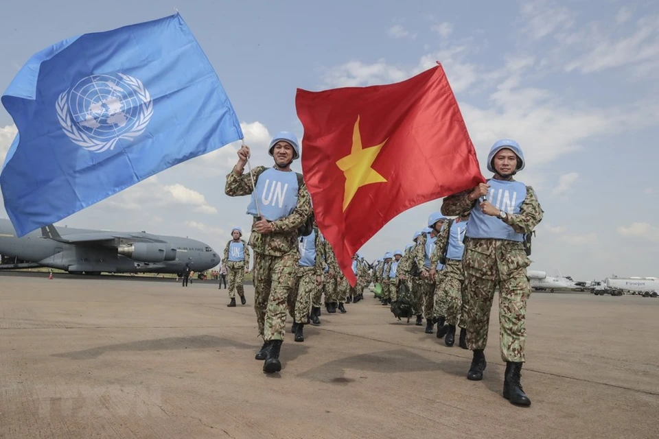 越南医务人员高举联合国旗帜和越南国旗，开始在南苏丹执行联合国维和行动任务。图自越通社