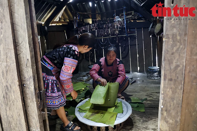 蒙族妇女准备香蕉叶，用火加热并用湿巾等将其擦干净，用来包糍粑。图自越通社