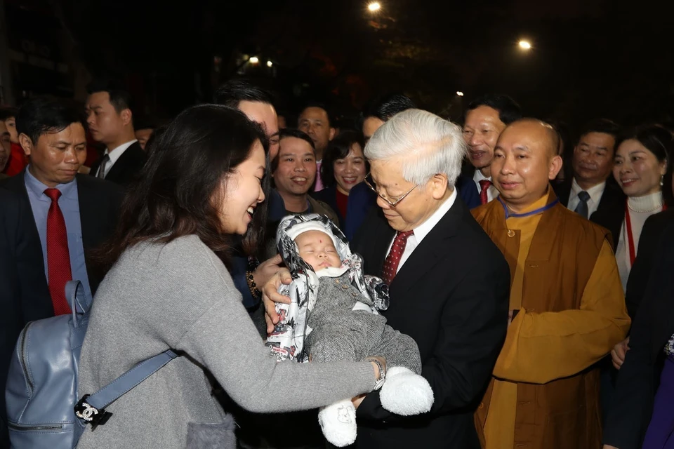 越共中央总书记阮富仲于农历丁酉年腊月除夕给在河内市还剑湖散布的居民拜年。越通社记者 志勇 摄