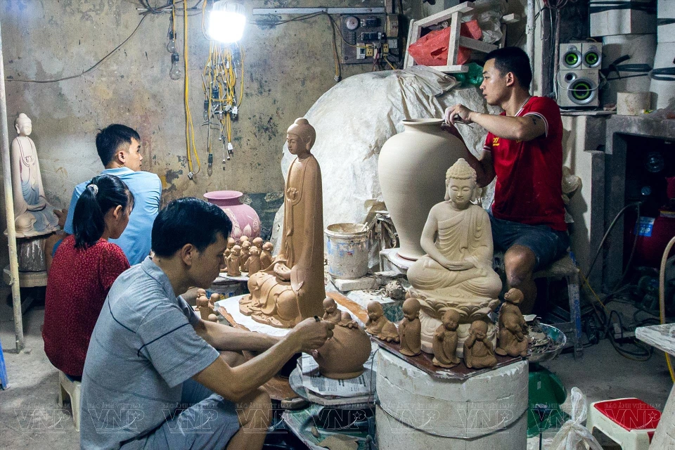 河内市钵场村陶瓷匠范明光至今从事陶器上的佛像与荷花绘制工作已有34年。图自越南画报