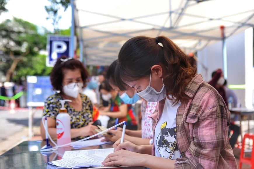 在河内综合医院接种点，二征夫人郡范廷虎坊人民在接种前都要进行健康申报。图自越通社