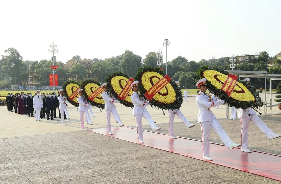 越南党、国家、祖国阵线中央委员会领导和原领导代表团的花圈飘带上写着“永远铭记胡志明主席的伟大功劳”。