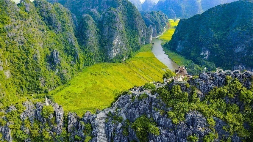 山顶有一尊观音佛像，而在山脚下梧桐河的河流蜿蜒绕行山间，让乘船的游客纷纷随着河流参观三个自然洞穴。图自越通社