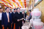 越南政府总理范明政参观手工艺品展位。图自越通社