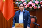越南政府总理范明政在政府驻地就为洪涝灾后民众修建、修缮房屋计划"光中战役"实施情况，与广治省委常委会召开工作会议。图自越通社