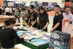 众多游客在博览会书籍展区参观。图自 越通社
