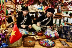 老街省展位工作人员为游客奉茶。图自 越通社