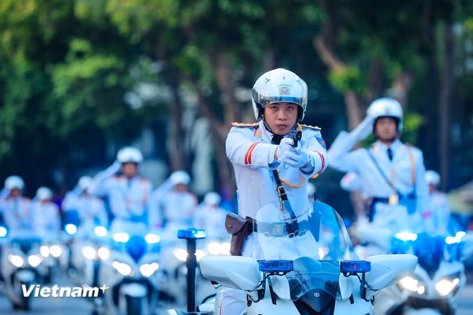 展示驾驶摩托时双手脱把、持枪射击的战术技能。图自越通社