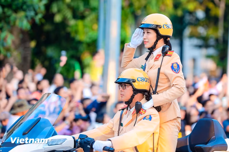 一位仪表端庄的女交警向观众敬礼。图自越通社