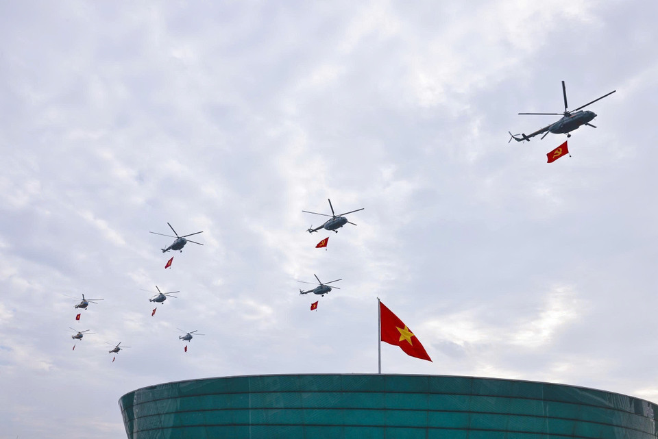 Mi-171、Mi-17、Mi-8直升机编队悬挂党旗与国旗飞越巴亭广场。图自越通社