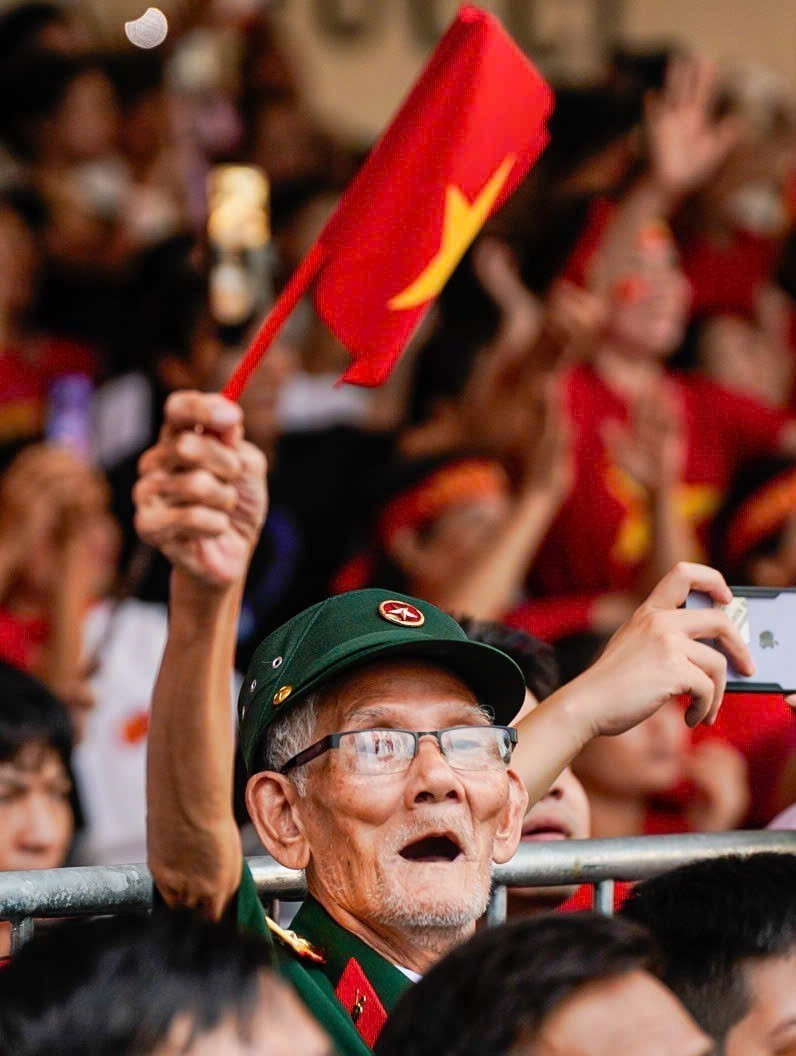 一位老兵为阅兵队伍热情鼓舞。图自越通社