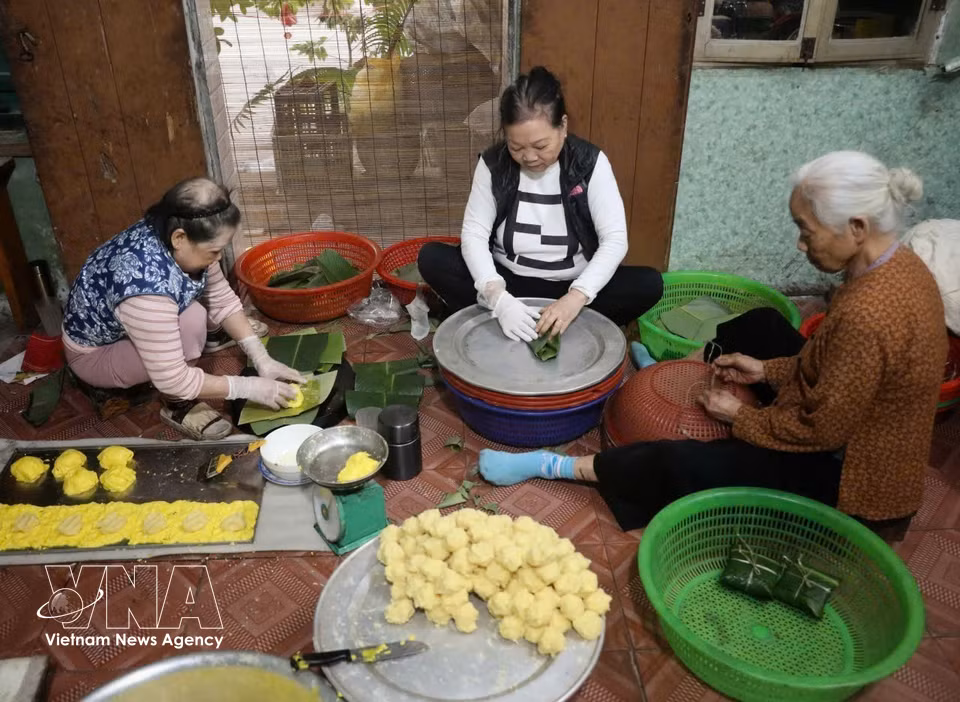 亭榜村一家作坊正在包夫妻饼。图自越通社