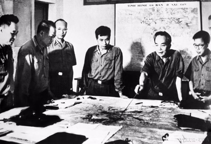 1975年4月14日，越共中央政治局决定将西贡—嘉定解放战役命名为胡志明战役，口号为“迅速、大胆、奇袭、必胜”。图中：武元甲大将与中央军委同志们审查胡志明战役（1975年4月）作战计划。图自越通社
