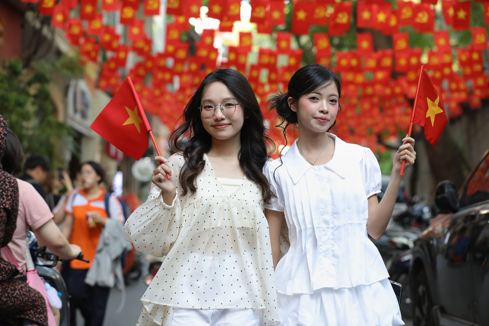 幼赵街上飘扬着金星红旗，吸引许多年轻人前来拍照，共同庆祝4·30的节日气氛。图自越通社