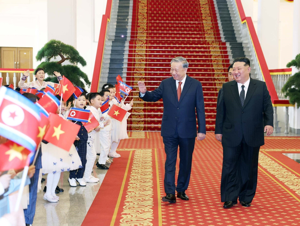越共中央总书记苏林、朝鲜劳动党总书记、国务委员长金正恩与朝鲜儿童在欢迎仪式上互动。 图自越通社