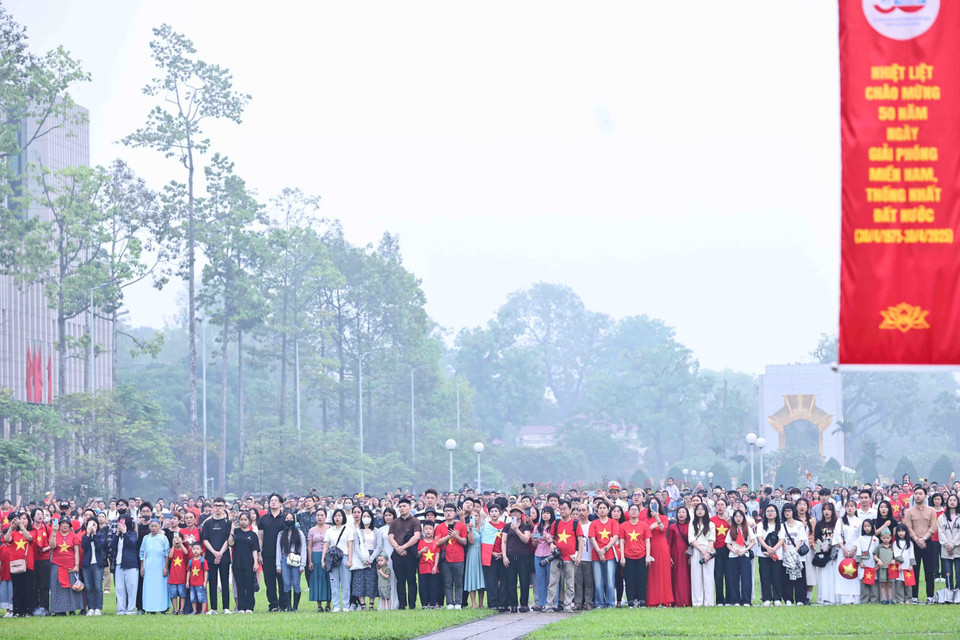 从清晨开始，人们就来到巴亭广场观看庄严的升旗仪式，庆祝越南南方解放和祖国统一50周年。（图：越通社）