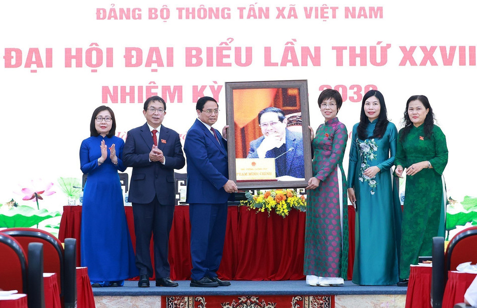 越通社社长武越庄向政府总理范明政赠送纪念照片。图自越通社