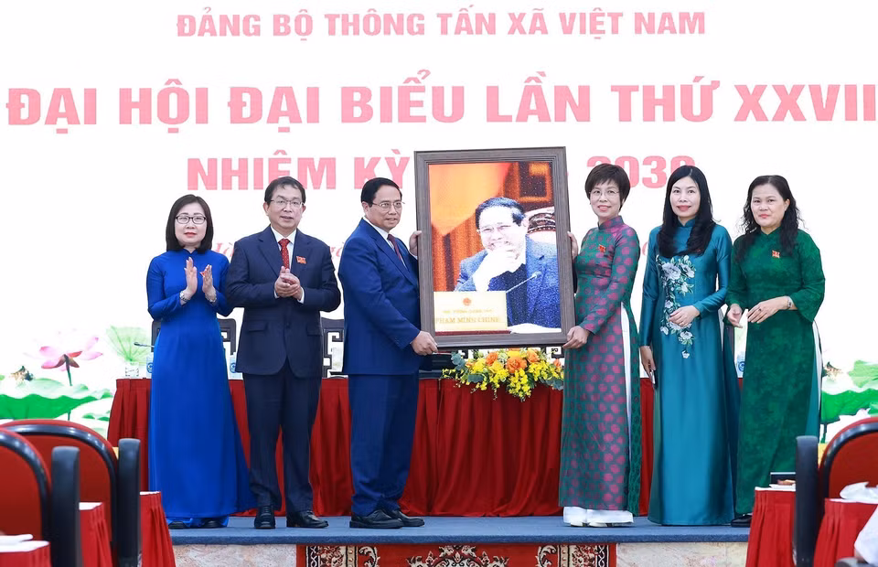 越通社社长武越庄向政府总理范明政赠送纪念照片。图自越通社