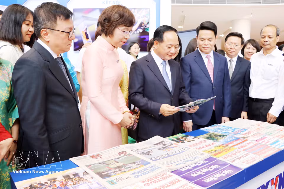 越共中央政治局委员、中央书记处书记、中央宣教与民运部部长郑文决与各位领导、代表参观越南通讯社在2026全国报刊展的展位。图自越通社