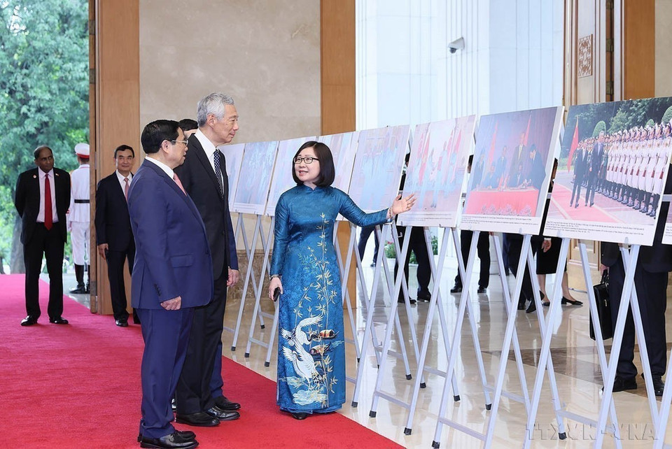 越南政府总理范明政与新加坡总理李显龙共同参观由越南通讯社制作的越新建交50周年和建立战略伙伴关系10周年图片展（河内，2023年8月28日）。图自越通社