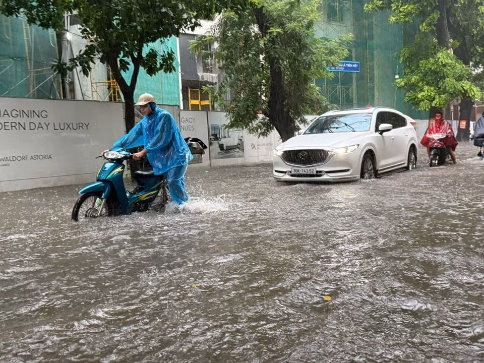 邓泰申街（南门坊）积水严重，一些摩托车熄火，被迫推行。图自越通社。