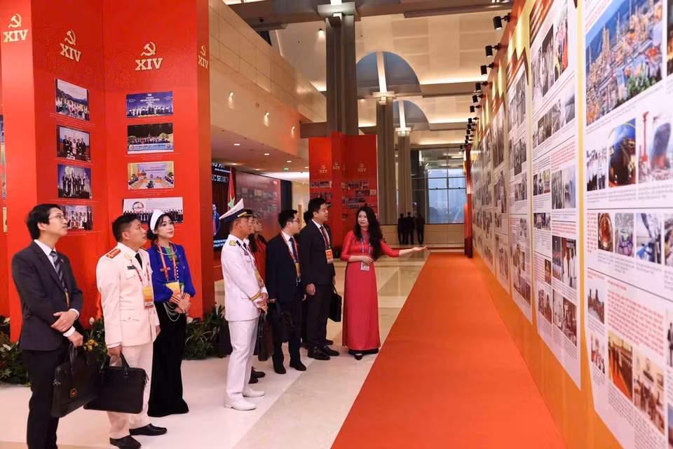 各位代表参观越南通讯社的图片展。图自越通社