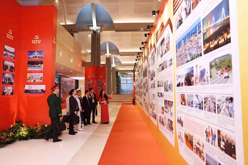 各位代表参观越南通讯社的图片展。图自越通社