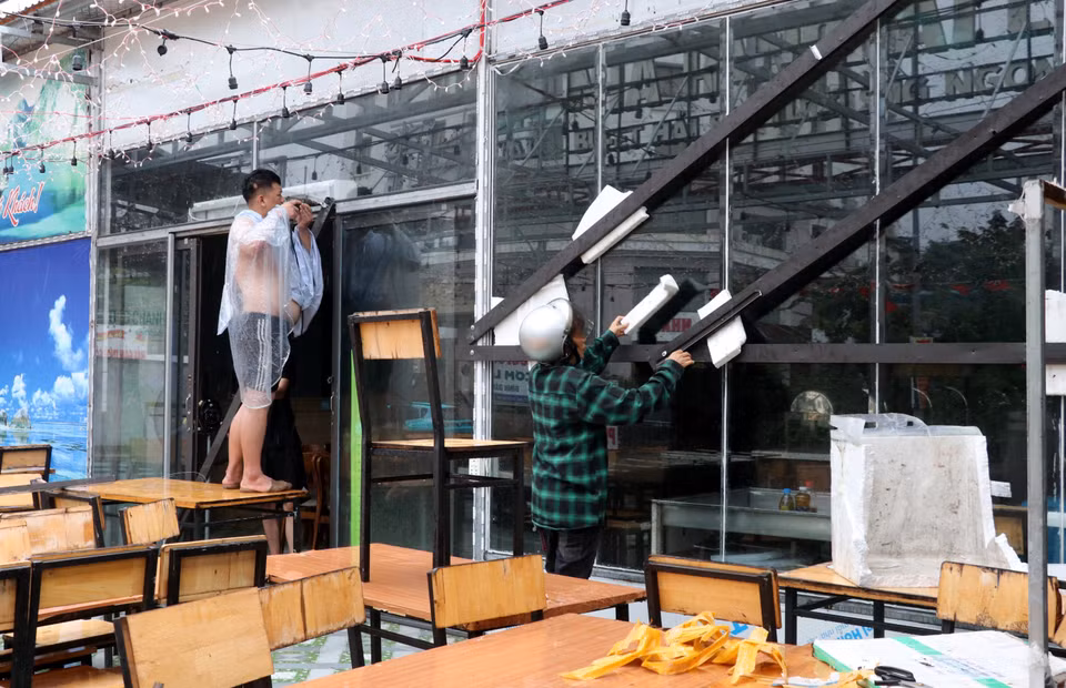 下龙市白斋坊一家海鲜餐厅加固玻璃门窗以防风暴。图自越通社