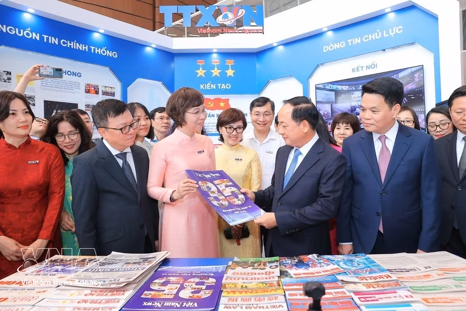 越共中央政治局委员、中央书记处书记、中央宣教与民运部部长郑文决与各位领导、代表参观越南通讯社在2026全国报刊展的展位。图自越通社